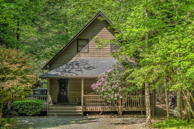 view of front of house with roof with shingles and a wooden deck