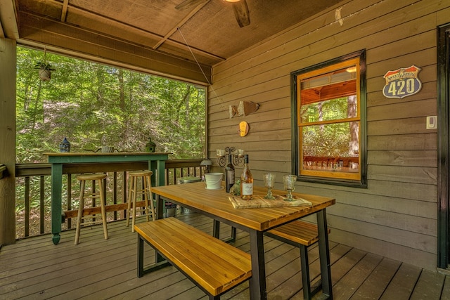 wooden terrace with a ceiling fan and outdoor dining space