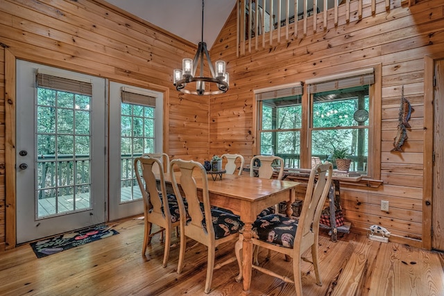 dining room featuring light wood finished floors, wood walls, and plenty of natural light