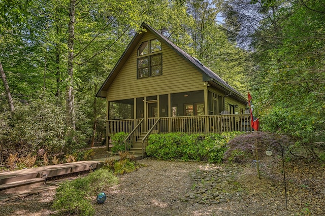 back of property featuring stairs and a sunroom