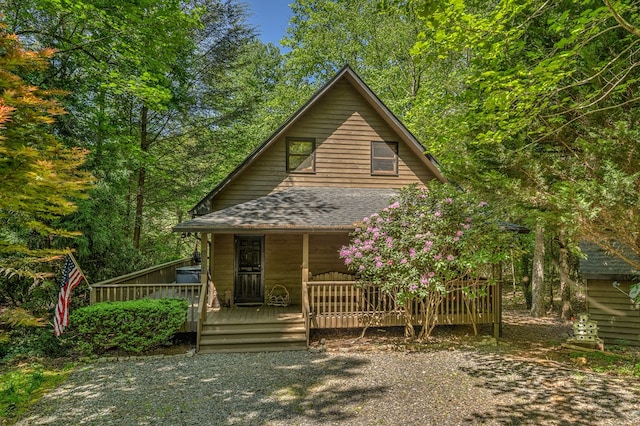 rustic home with a shingled roof and a porch