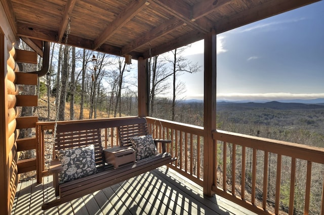 wooden deck featuring a mountain view and a view of trees