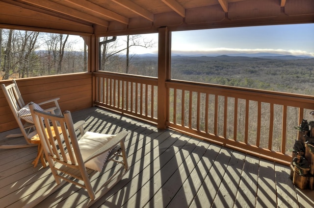 wooden terrace with a forest view and a mountain view