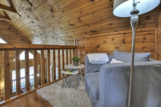 sitting room featuring wooden ceiling, wooden walls, wood finished floors, and lofted ceiling