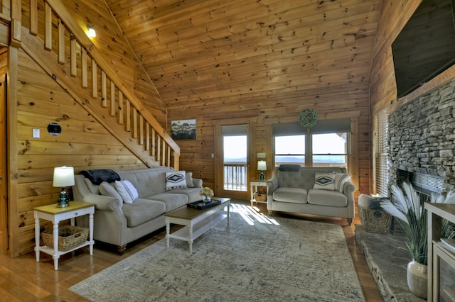 living area featuring wood ceiling, stairway, wooden walls, and wood finished floors