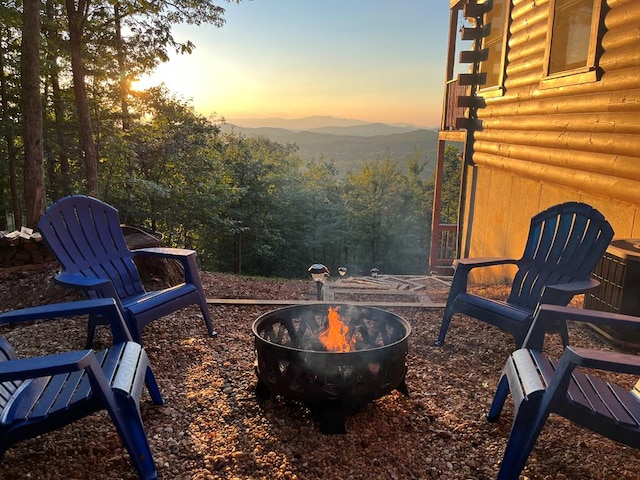 patio terrace at dusk with a mountain view and an outdoor fire pit