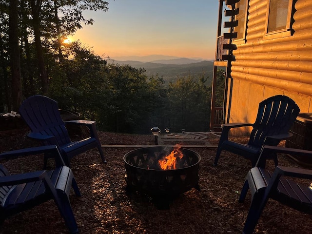 patio terrace at dusk with a fire pit and a mountain view