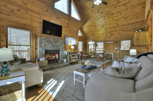 living area with plenty of natural light, wood walls, and a fireplace