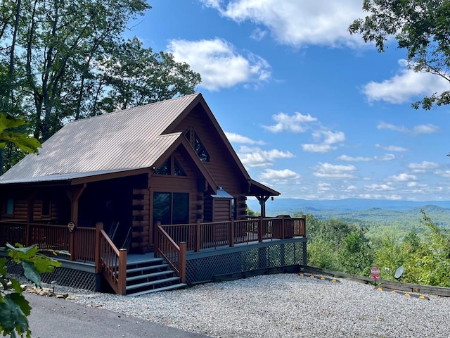 log home with log exterior, a mountain view, and metal roof