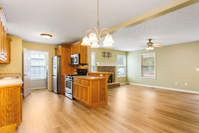 421 Burgess Rd, Ellijay, GA 30540 - kitchen featuring stainless steel appliances, open floor plan, light wood-style flooring, brown cabinets, and a textured ceiling