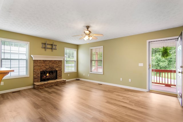 421 Burgess Rd, Ellijay, GA 30540 - unfurnished living room featuring a textured ceiling, light wood-type flooring, ceiling fan, a fireplace, and baseboards