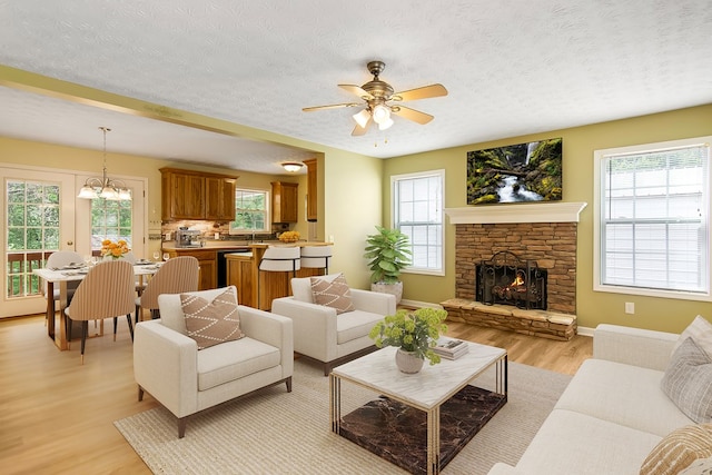 421 Burgess Rd, Ellijay, GA 30540 - living room featuring light wood-style flooring, plenty of natural light, a ceiling fan, a textured ceiling, and a fireplace