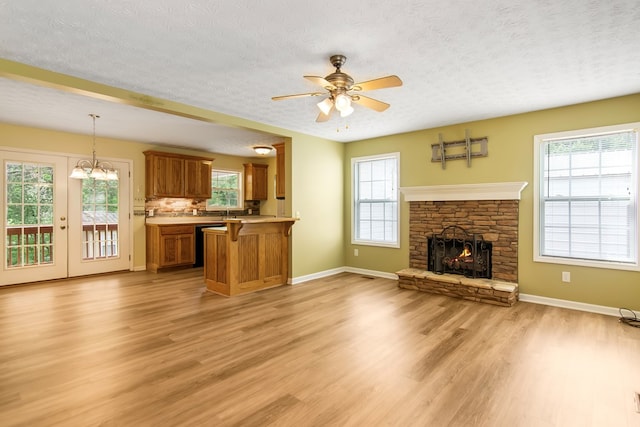 421 Burgess Rd, Ellijay, GA 30540 - unfurnished living room with light wood-style flooring, ceiling fan, a textured ceiling, baseboards, and a stone fireplace