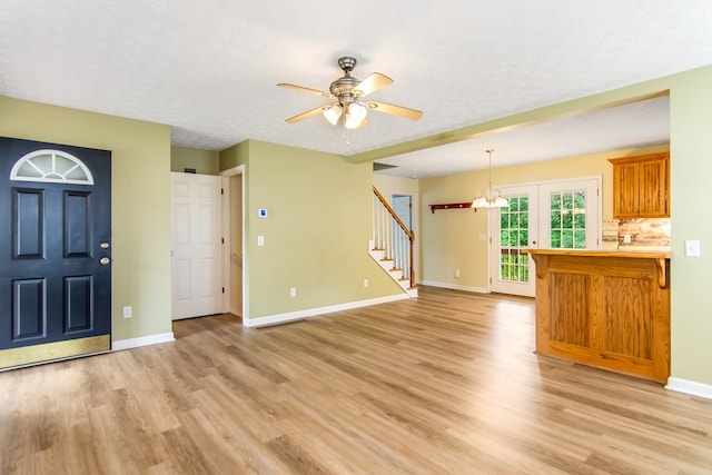 421 Burgess Rd, Ellijay, GA 30540 - unfurnished living room featuring light wood finished floors, baseboards, a ceiling fan, stairs, and a chandelier