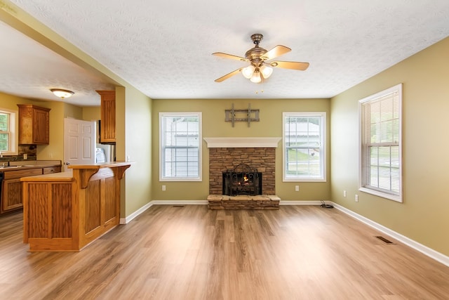 421 Burgess Rd, Ellijay, GA 30540 - unfurnished living room with light wood-style flooring, a textured ceiling, ceiling fan, a sink, and baseboards