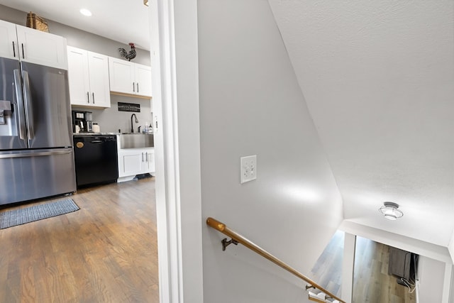 429 Sneaking Creek Dr, Hayesville, NC 28904 - kitchen with stainless steel fridge, dishwasher, light wood-type flooring, white cabinetry, and a sink