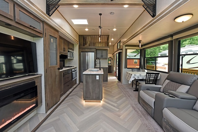 201 Kole Dr, Blairsville, GA 30512 - kitchen featuring appliances with stainless steel finishes, open floor plan, light countertops, a sink, and a kitchen island with sink