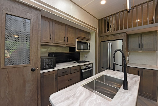 201 Kole Dr, Blairsville, GA 30512 - kitchen with appliances with stainless steel finishes, a sink, light countertops, decorative backsplash, and dark brown cabinets