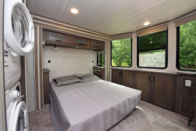 201 Kole Dr, Blairsville, GA 30512 - bedroom with stacked washer / dryer, multiple windows, light colored carpet, recessed lighting, and wooden walls