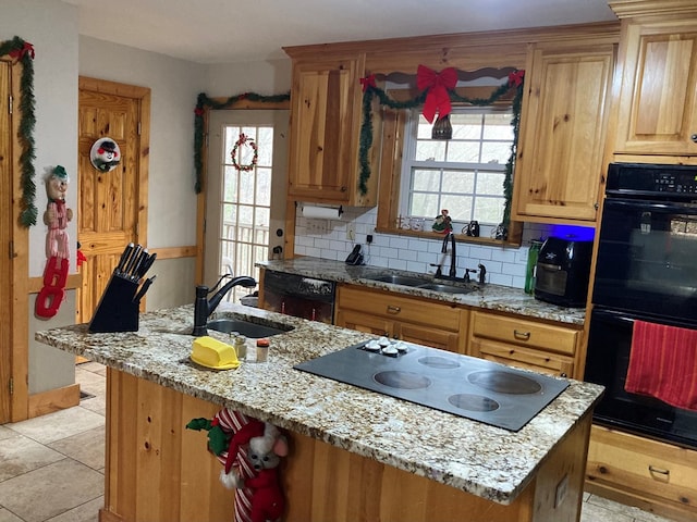 kitchen with black appliances, decorative backsplash, light stone countertops, and sink