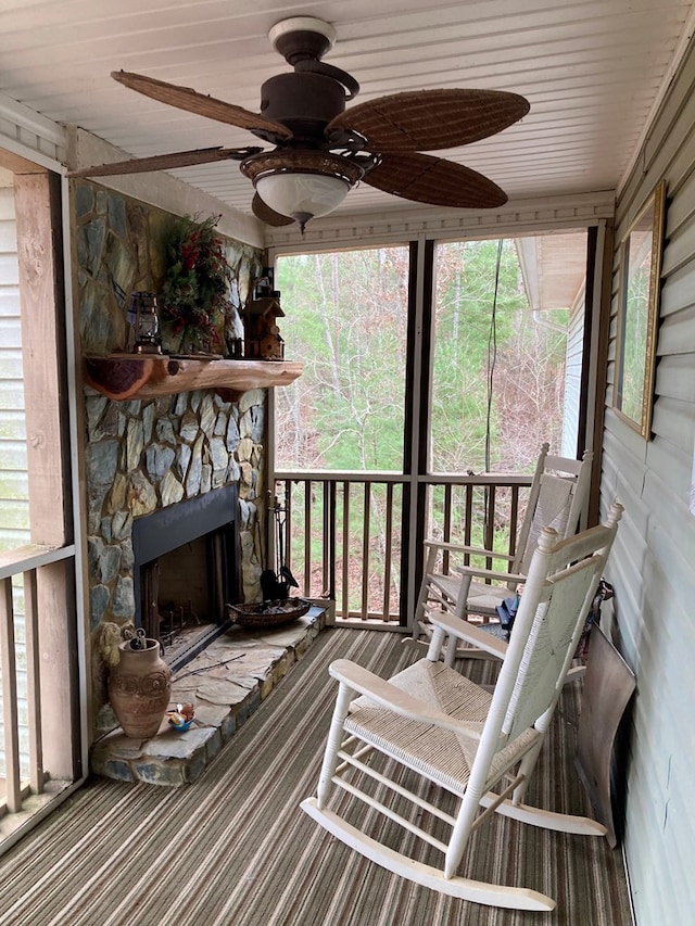 sunroom / solarium with ceiling fan, wood ceiling, and a fireplace