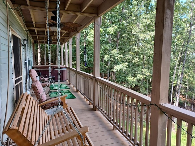 wooden deck with ceiling fan and a hot tub