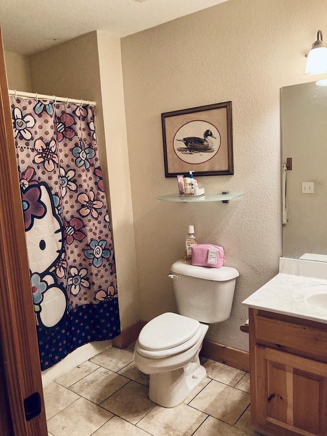 bathroom featuring tile patterned floors, vanity, and toilet