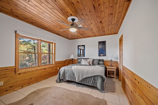 bedroom featuring wood walls, ceiling fan, wooden ceiling, and light tile patterned floors