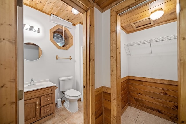 bathroom with vanity, wood ceiling, wood walls, and tile patterned flooring