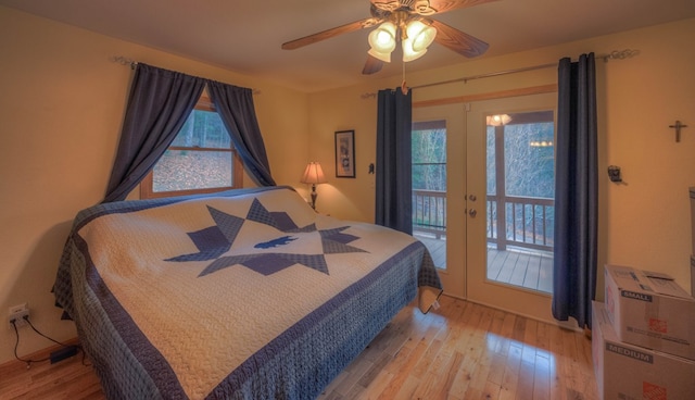 bedroom with access to outside, light wood-type flooring, multiple windows, and ceiling fan