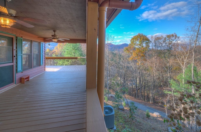 wooden terrace with central AC unit, a mountain view, and ceiling fan