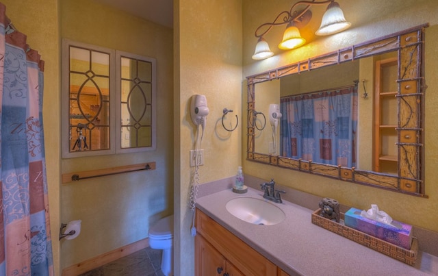 bathroom with curtained shower, tile patterned flooring, vanity, and toilet