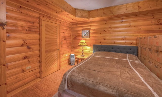 bedroom with wood-type flooring and rustic walls