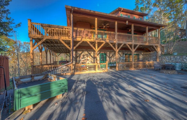 rear view of property with ceiling fan and a wooden deck