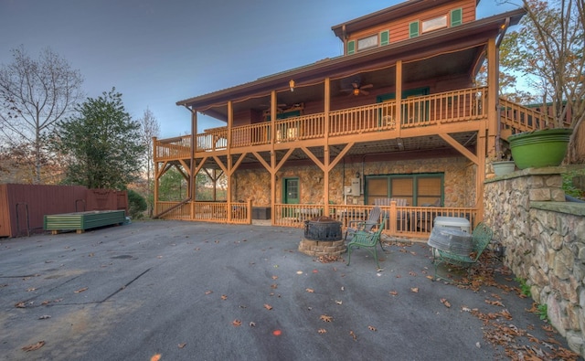 rear view of property featuring a patio area, ceiling fan, and a balcony