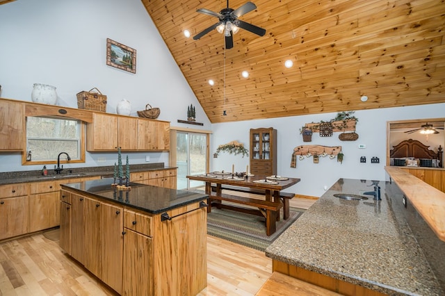 kitchen featuring a center island, wooden ceiling, a sink, and light wood finished floors