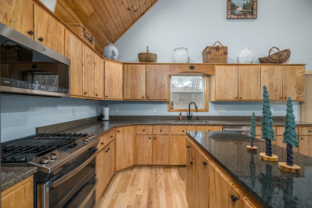 kitchen featuring wood ceiling, appliances with stainless steel finishes, dark stone countertops, light wood-style floors, and a sink