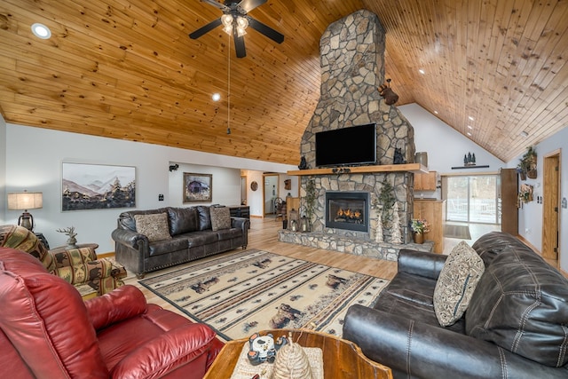 living area featuring wood ceiling, ceiling fan, a stone fireplace, wood finished floors, and high vaulted ceiling