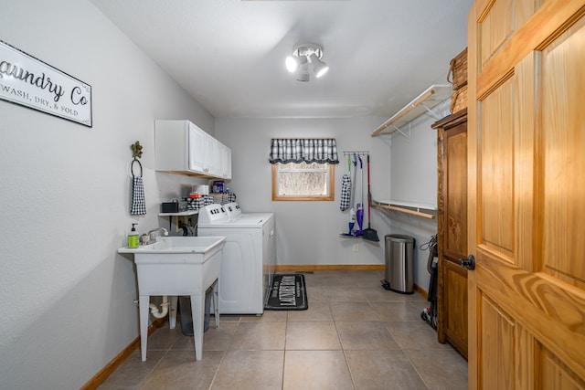 laundry room with light tile patterned floors, washing machine and dryer, cabinet space, and baseboards