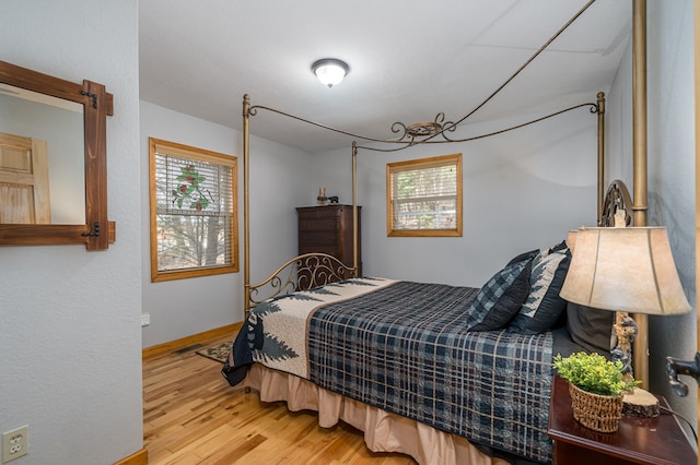 bedroom featuring wood finished floors and baseboards