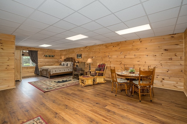 bedroom with wood walls and wood finished floors