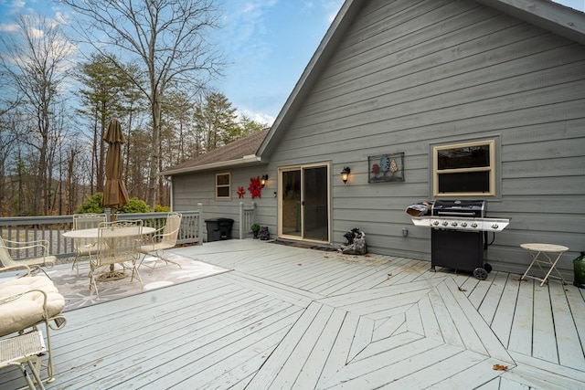 wooden deck with outdoor dining space and grilling area