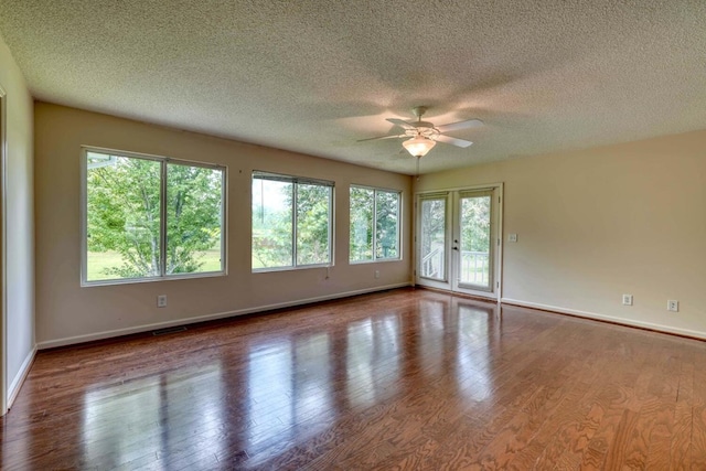 spare room with ceiling fan, a textured ceiling, and wood-type flooring