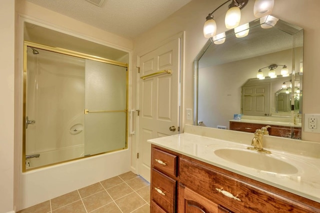 bathroom with a textured ceiling, tile patterned floors, vanity, and enclosed tub / shower combo