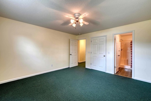 unfurnished bedroom with ceiling fan, connected bathroom, a textured ceiling, and dark colored carpet