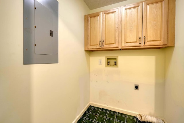 washroom with electric dryer hookup, dark tile patterned flooring, cabinets, hookup for a washing machine, and electric panel