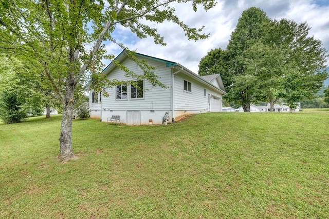 view of home's exterior with a garage and a yard