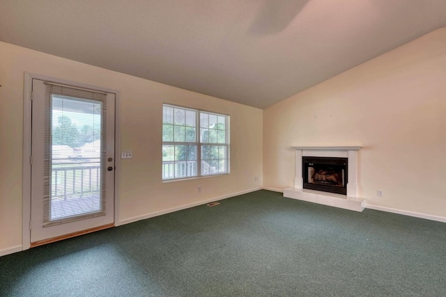 unfurnished living room with carpet, vaulted ceiling, and a wealth of natural light