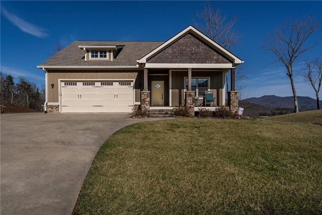 craftsman-style house with an attached garage, a mountain view, covered porch, a front lawn, and board and batten siding