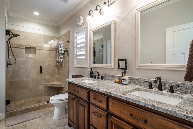 bathroom with crown molding, a stall shower, a sink, and double vanity